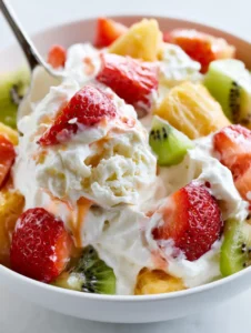 Extreme macro close-up of Hawaiian Cheesecake Salad showing velvety cream, red strawberries, and golden pineapple.