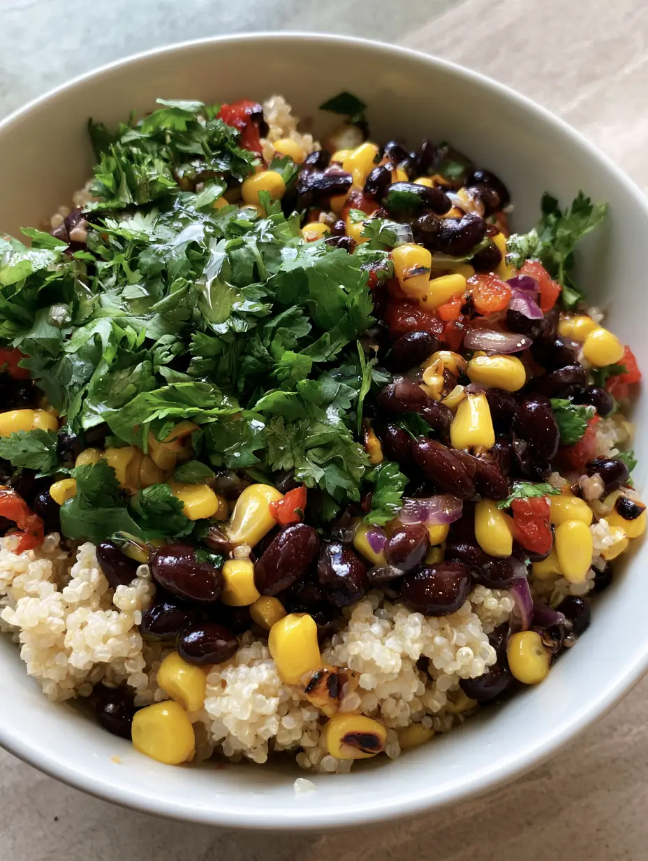 Close-up high-angle photo of fluffy Sweet Corn and Black Bean Quinoa Salad featuring glossy black beans and charred corn kernels.