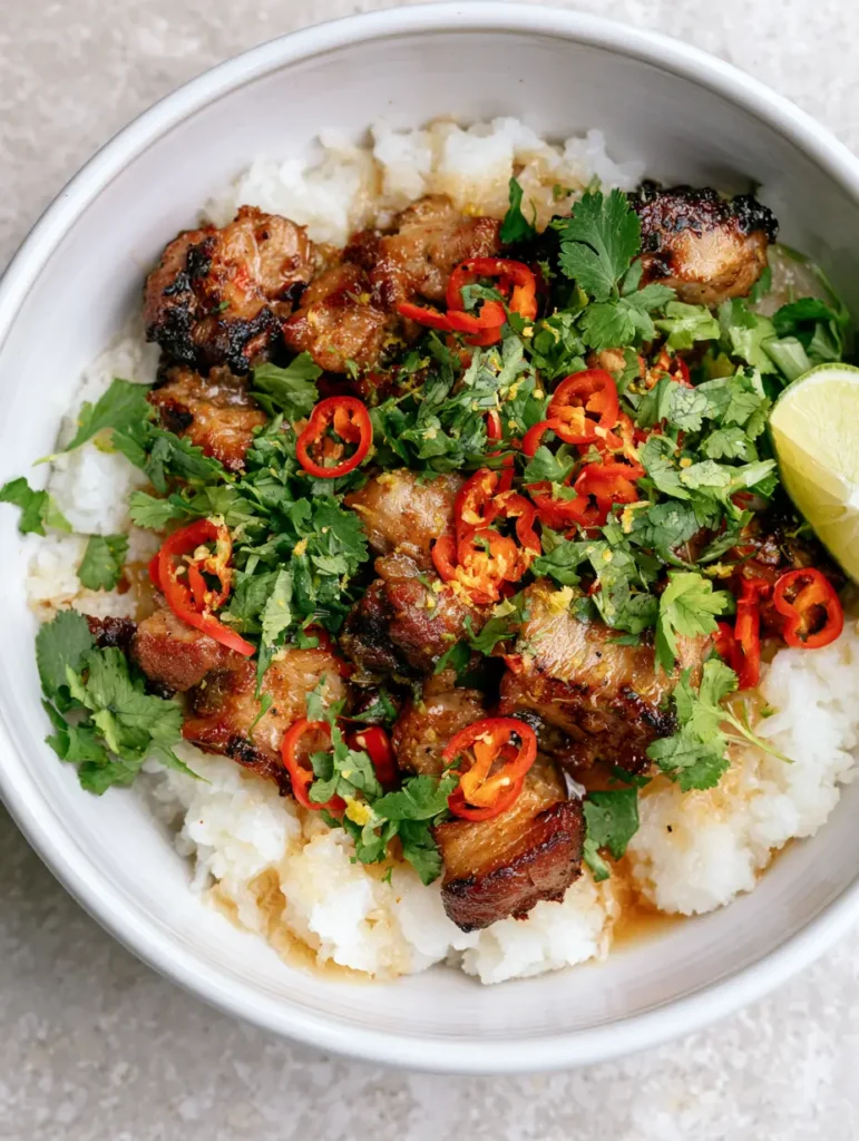 Ginger Lime Pork with Fluffy Coconut Rice and Glossy Zesty Glaze 2 Close-up of seared golden pork cubes coated in a glossy ginger lime glaze with red chili rounds and lime zest. (Ginger Lime Pork)
