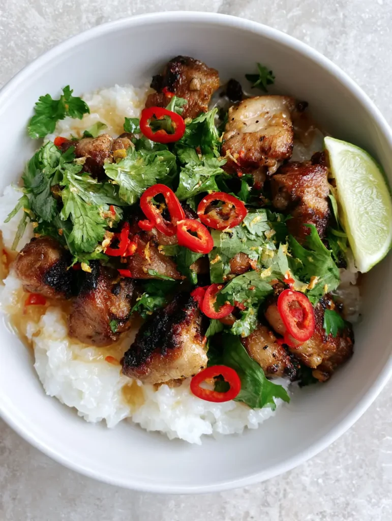 Ginger Lime Pork with Fluffy Coconut Rice and Glossy Zesty Glaze 1 Steaming bowl of Ginger Lime Pork over fluffy white coconut rice on a grey stone background.