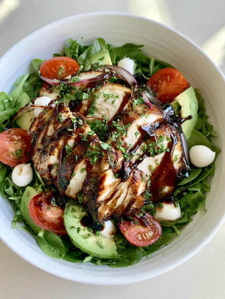 Baked Chicken Salad with Balsamic Glaze and Creamy Avocado 1 A colorful Baked Chicken Salad bowl with mozzarella pearls, cherry tomatoes, and red onion.