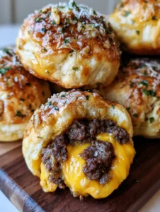 A smartphone photo of several Cheeseburger Bombs brushed with garlic and parsley, highlighting the crispy golden crust.