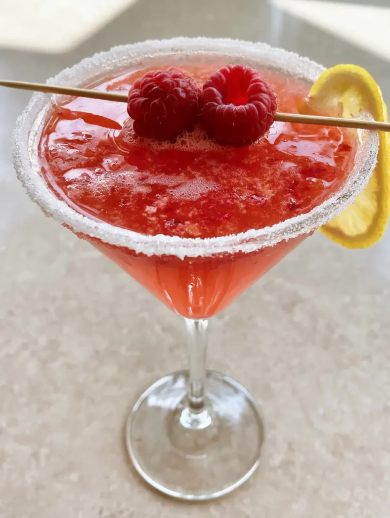 Raspberry Lemon Drop Martini: The Ultimate Vibrant Pink Cocktail Guide 2 Close up of a Raspberry Lemon Drop Martini showing the light cocktail froth and granulated sugar rim.