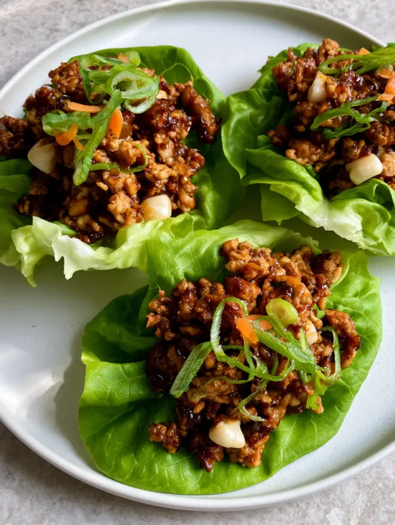 PF Chang’s Chicken Lettuce Wraps: The Ultimate 20-Minute Copycat 1 Detailed shot of the minced chicken mixture for PF Chang’s Chicken Lettuce Wraps, showing the uniform white cubes of water chestnuts and the dark, glossy glaze.