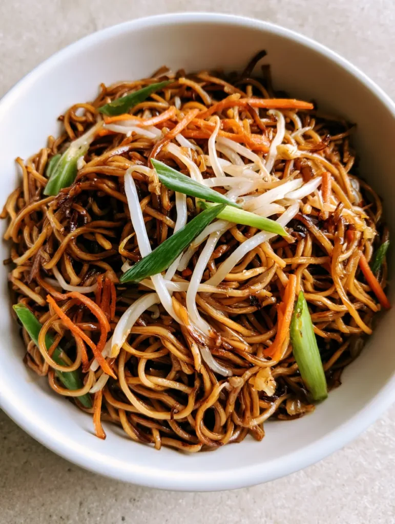 Detailed view of charred wheat noodles and translucent bean sprouts in a Chow Mein Recipe bowl.