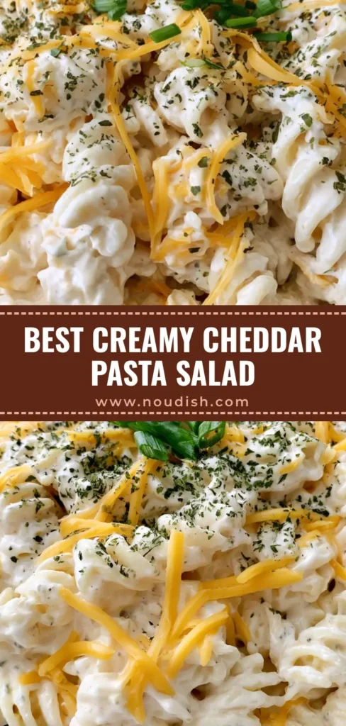 Creamy Cheddar Pasta Salad with Rich Sour Cream Dressing 4 A shallow white bowl filled with Creamy Cheddar Pasta Salad showing rotini pasta in ivory dressing with yellow cheese strands and green chives.