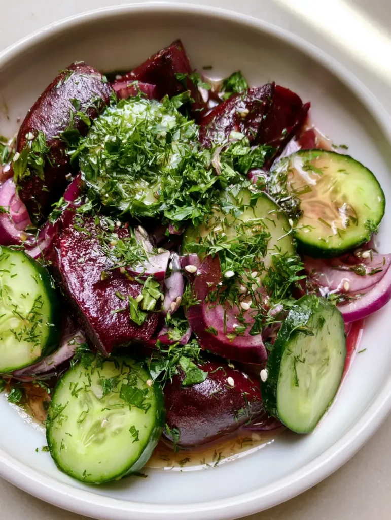 Beetroot and Cucumber Salad with Roasted Wedges and Fresh Herbs 1 Close up shot of roasted purple beetroot wedges and crisp cucumber rounds in a Beetroot and Cucumber Salad.