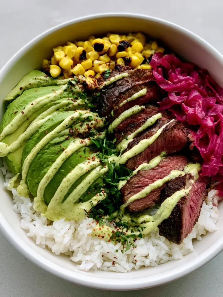 Top down view of the complete Steak and Avocado Bowl showing charred corn and pickled red onions.