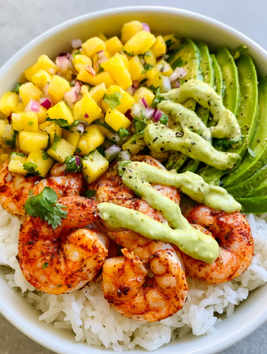 Close-up of a Tropical Shrimp Rice Bowl showing the reddish-brown spice rub on charred shrimp and bright yellow pineapple salsa.