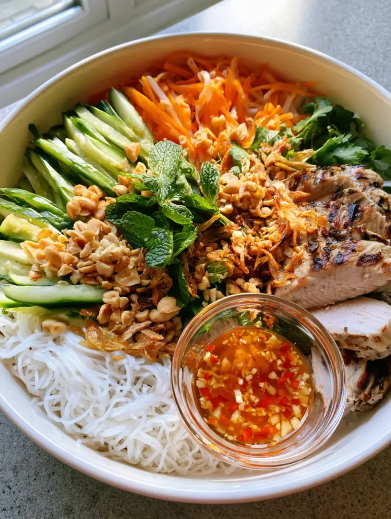 Detailed shot of seared lemongrass protein and amber fish sauce dressing with chili for Vietnamese Noodle Salad.