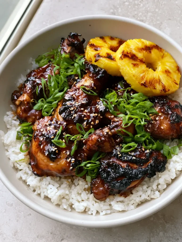 Huli Huli Chicken: The Ultimate Mahogany Glazed Hawaiian BBQ 1 Handheld photo showing Huli Huli Chicken with grilled pineapple rings and sesame seeds.