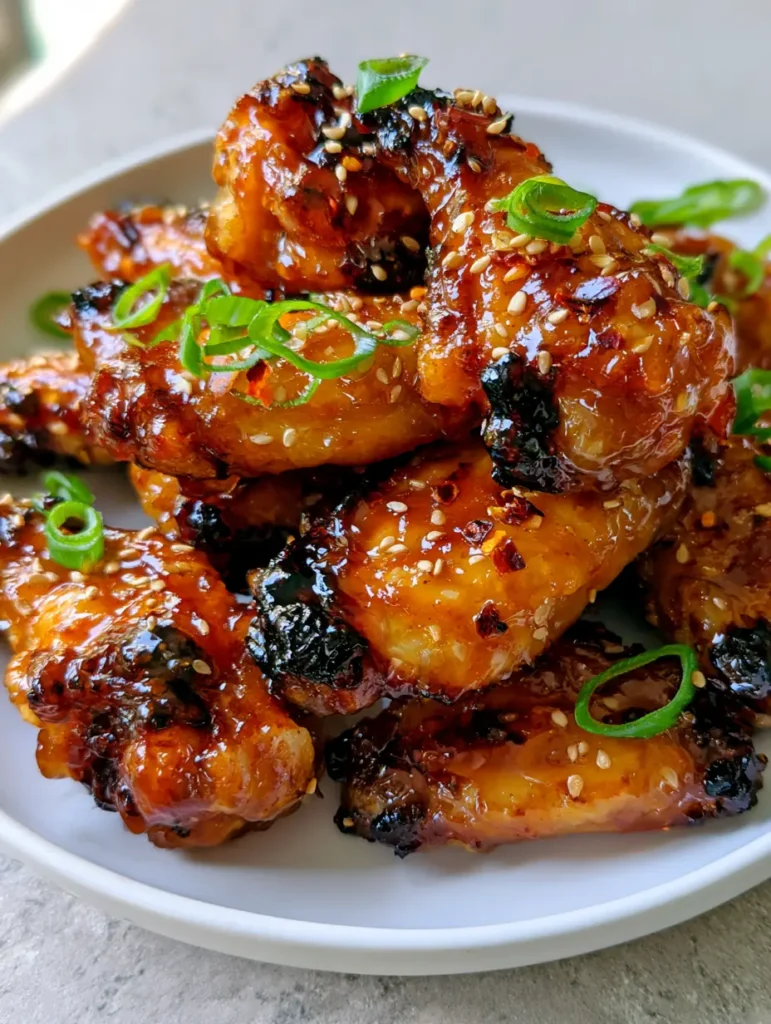 Overhead shot of Brown Sugar Pineapple Wings served on a white plate on a grey stone surface.