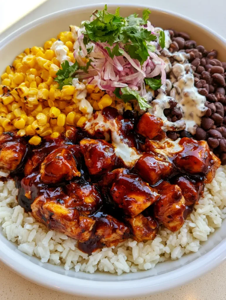 BBQ Chicken Rice Bowls: The Ultimate 20-Minute Weekday Meal 1 Deconstructed BBQ Chicken Rice Bowls with fresh cilantro and messy ranch drizzle in a white ceramic bowl.