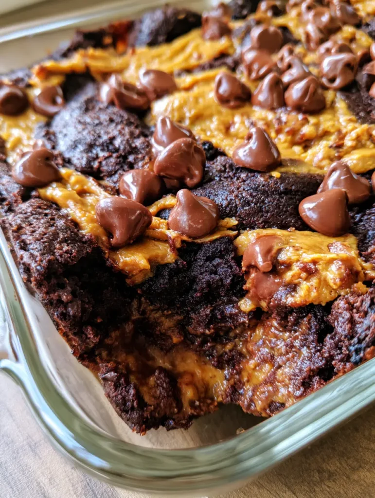 Clear glass baking dish showing the caramelized edges and moist dark chocolate crumb of a dump cake.