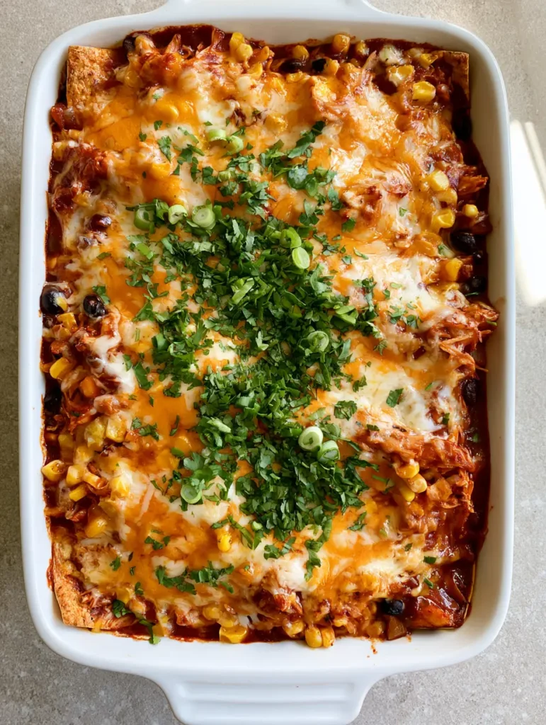 Chicken Enchilada Casserole: The Ultimate Cheesy Weeknight Dinner 2 Close-up of melted cheddar and monterey jack cheese on top of a Chicken Enchilada Casserole with glossy red sauce.