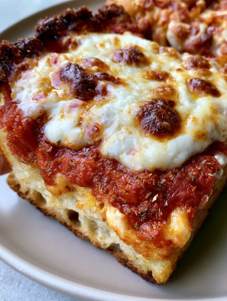 Sicilian Pizza Recipe: The Ultimate Crispy and Airy Thick Crust 2 Detailed view of the focaccia-like crumb and golden crispy crust of a Sicilian Pizza Recipe.